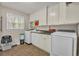 Bright laundry room with modern washer and dryer, ample cabinet space, and a utility sink at 4336 Yancey Rd, Douglasville, GA 30135