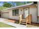 A view of the house's front door entrance with a small wooden porch and a garage in the background at 5286 Westhill Dr, Norcross, GA 30071