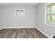 A bright bedroom featuring modern gray walls, wood floors, and bright natural light at 3711 Daisy Dr, Decatur, GA 30032