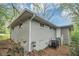Home exterior showing gray painted brick, gutters, and access to the basement at 3711 Daisy Dr, Decatur, GA 30032