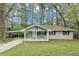 Charming single-story home with a covered front porch and well-maintained lawn surrounded by mature trees at 3711 Daisy Dr, Decatur, GA 30032