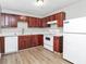 Bright kitchen with white countertops, cherry cabinets, modern appliances, and wood-look flooring at 3711 Daisy Dr, Decatur, GA 30032