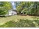 View of a spacious backyard with lush green lawn, partially shaded by mature trees at 3765 Michaels Way, Cumming, GA 30040