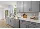 Stylish kitchen featuring gray cabinets, quartz countertops, stainless steel appliances and hardwood floors at 3765 Michaels Way, Cumming, GA 30040