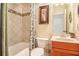 Cozy bathroom featuring a shower and tub combo, decorative tile, and wooden vanity with sink at 3907 Fellowship Dr, Buford, GA 30519
