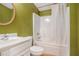 Bathroom with a white sink vanity, a golden mirror on an olive green wall and a white shower and bath at 3907 Fellowship Dr, Buford, GA 30519