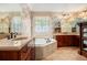 Large bathroom showcasing dual vanities, a jacuzzi-style tub, and a decorative window at 3907 Fellowship Dr, Buford, GA 30519
