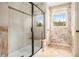 Bathroom featuring a glass shower, seat, and a window letting in natural light at 3907 Fellowship Dr, Buford, GA 30519