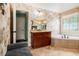 Bathroom features a soaking tub, a vanity, tile floors, and textured wall paper at 3907 Fellowship Dr, Buford, GA 30519