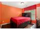 A bedroom with a wooden bed frame, red bedding, a window, and hardwood floors at 3907 Fellowship Dr, Buford, GA 30519