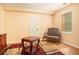 An empty bedroom with a patterned chair, a wooden table on a patterned rug, and a wooden dresser at 3907 Fellowship Dr, Buford, GA 30519