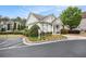 Exterior view of a community clubhouse with a parking area, landscaping, and manicured bushes at 3907 Fellowship Dr, Buford, GA 30519