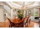 Formal dining room with hardwood floors, elegant chandelier, and large windows offering natural light at 3907 Fellowship Dr, Buford, GA 30519