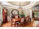 Elegant dining room with tray ceilings, wooden floors, large windows, and natural lighting at 3907 Fellowship Dr, Buford, GA 30519