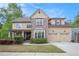 Charming two-story home with a well-manicured lawn, a two-car garage, and a covered front porch at 3907 Fellowship Dr, Buford, GA 30519