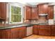 Kitchen featuring stainless steel appliances, dark cabinets, granite counters, and views of the wooded backyard at 3907 Fellowship Dr, Buford, GA 30519