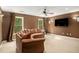 Living room with plush sofa, a ceiling fan, wall sconces, large windows and a flat screen TV at 3907 Fellowship Dr, Buford, GA 30519