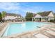 Community pool area featuring lounge chairs, tables, and a clubhouse under a partly cloudy sky at 3907 Fellowship Dr, Buford, GA 30519