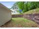 Backyard with wooden retaining wall and grassy area provides a quiet outdoor space at 1899 Cooper Landing Se Dr, Smyrna, GA 30080