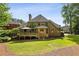 Well-maintained backyard with mature trees and an outdoor deck area at 9075 Preston Ln, Suwanee, GA 30024