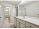 Neutral bathroom features a spacious vanity with white countertop and large mirror at 9075 Preston Ln, Suwanee, GA 30024