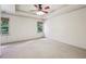 Spacious bedroom with neutral carpet, ceiling fan and two bright windows at 9075 Preston Ln, Suwanee, GA 30024