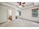 Large bedroom with ceiling fan, windows, and an ensuite bathroom with vanity at 9075 Preston Ln, Suwanee, GA 30024