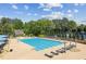 Large community pool with lounge chairs, umbrellas, and lush greenery surrounding the area at 9075 Preston Ln, Suwanee, GA 30024
