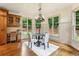 Bright dining area with hardwood floors, wainscoting, modern chandelier, and views of the landscaped yard at 9075 Preston Ln, Suwanee, GA 30024