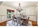 Elegant dining room featuring a decorative chandelier, wainscoting, and natural light at 9075 Preston Ln, Suwanee, GA 30024