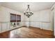 Bright dining room with hardwood floors, decorative wainscoting, and an elegant chandelier at 9075 Preston Ln, Suwanee, GA 30024