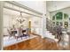 Bright dining room with chandelier and wainscoting near staircase with large windows and view to the living room at 9075 Preston Ln, Suwanee, GA 30024