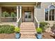 Inviting front entrance with brick steps leading to a covered porch and stylish double doors at 9075 Preston Ln, Suwanee, GA 30024