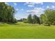 Lush golf course landscape, complete with mature trees, rolling hills, and immaculate green fairways at 9075 Preston Ln, Suwanee, GA 30024