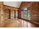 Elegant home office with custom wood paneling, built-in bookshelves, and a large window at 9075 Preston Ln, Suwanee, GA 30024