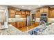 Gourmet kitchen features custom wood cabinetry, stainless steel appliances, and granite counters at 9075 Preston Ln, Suwanee, GA 30024