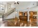 Open-concept living space with a grand staircase, hardwood floors, and an adjoining kitchen at 9075 Preston Ln, Suwanee, GA 30024