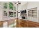 Spacious living room featuring large windows, a stone fireplace, and built-in shelving at 9075 Preston Ln, Suwanee, GA 30024