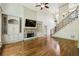 Spacious living room featuring a stone fireplace, built-in cabinets, and hardwood floors at 9075 Preston Ln, Suwanee, GA 30024