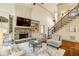 Comfortable living room featuring stone fireplace, built-in shelving, and adjacent staircase at 9075 Preston Ln, Suwanee, GA 30024