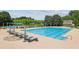 Spacious swimming pool area featuring multiple lounge chairs, umbrellas and a clear blue swimming pool at 9075 Preston Ln, Suwanee, GA 30024