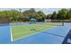 Well-maintained tennis court with blue and green surface, complete with shaded seating area for relaxing between sets at 9075 Preston Ln, Suwanee, GA 30024