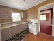 Compact kitchen features neutral cabinets, white appliances, and a window for natural light at 1683 Candler Rd, Decatur, GA 30032