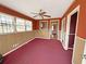 Bright living room with red carpet, wood paneling, ceiling fan, and multiple windows at 1683 Candler Rd, Decatur, GA 30032