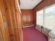 Sunroom features wood paneling, red carpet, and multiple windows for natural light at 1683 Candler Rd, Decatur, GA 30032