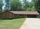 Charming brick home with well-maintained lawn, and carport, nestled amongst mature trees at 4141 Fredericksburg Dr, College Park, GA 30337