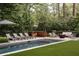 A pristine pool with lounge chairs and outdoor seating with lush trees in background at 1016 Wildwood Ne Rd, Atlanta, GA 30306