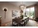 Light and airy dining area with a unique chandelier, modern art, and expansive windows overlooking the lush greenery at 1016 Wildwood Ne Rd, Atlanta, GA 30306