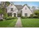 Charming white brick home featuring a well-kept lawn, stone pathway, and lush greenery at 1016 Wildwood Ne Rd, Atlanta, GA 30306