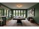 Green game room features a pool table, stools, and large windows overlooking the outdoors at 1016 Wildwood Ne Rd, Atlanta, GA 30306